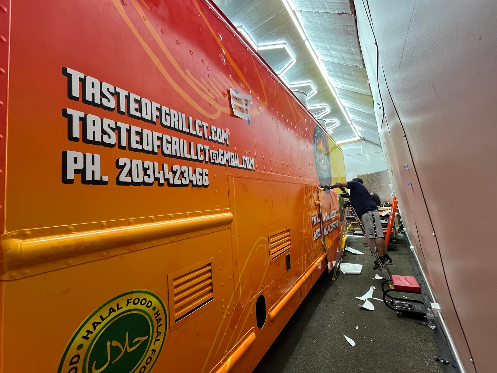 Side of the Taste of Grill food truck with website and phone lettering on the box