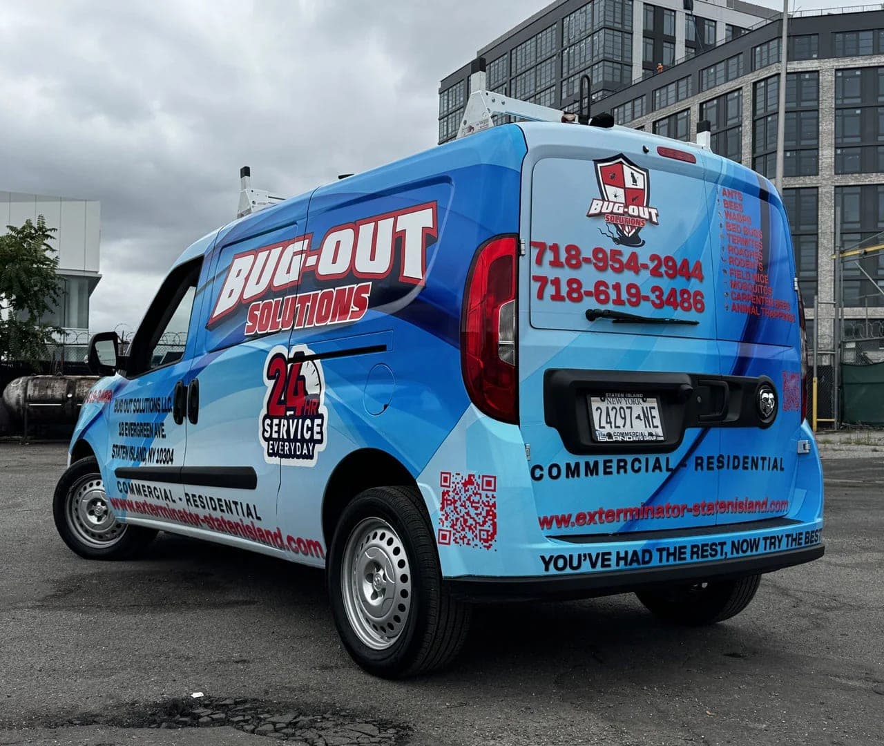 Rear three-quarter view of the Bug-Out Solutions van with logo, two phone numbers, a pest list and a QR code on the rear doors
