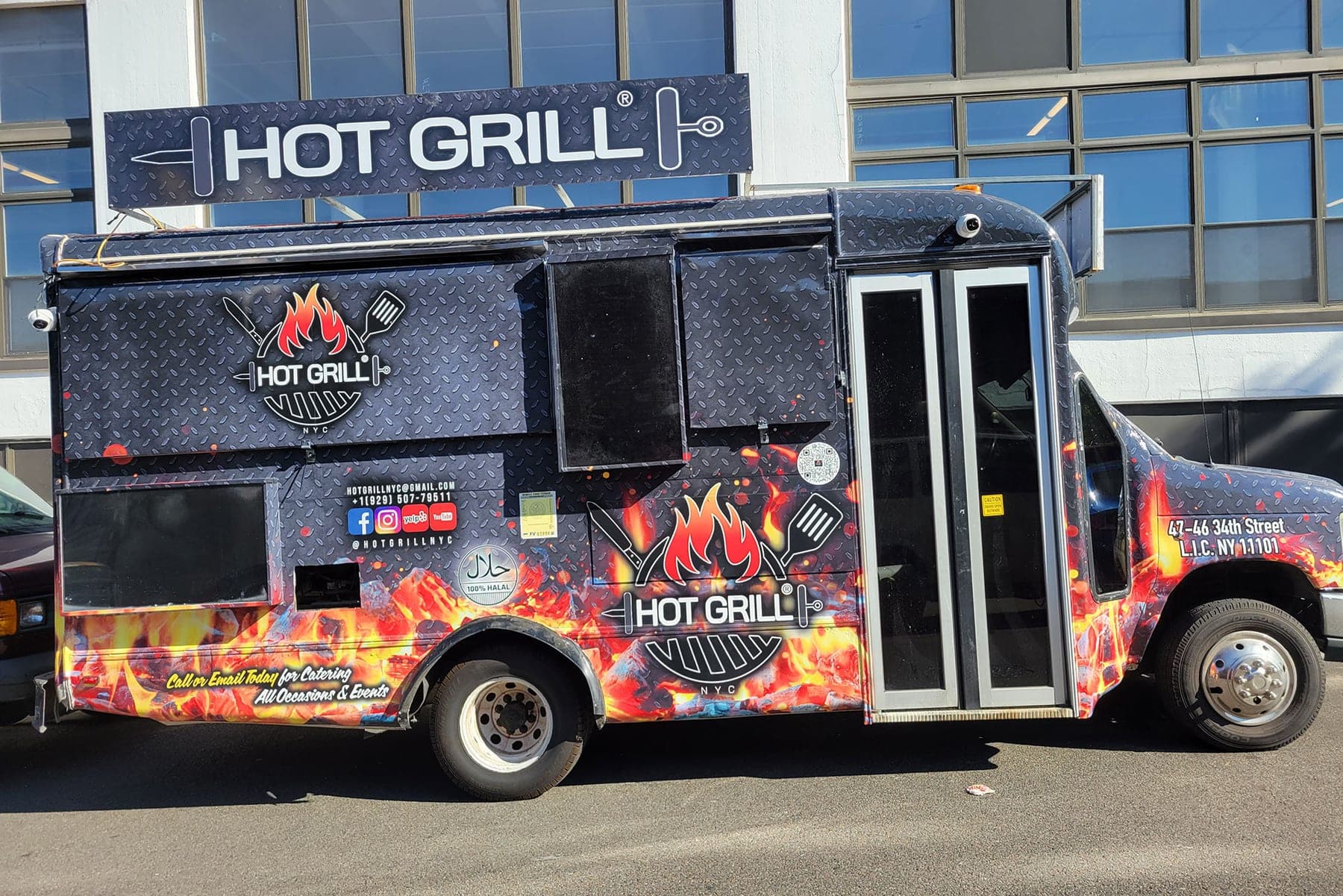 Black Hot Grill shawarma food truck with flame graphics and a printed menu on the side