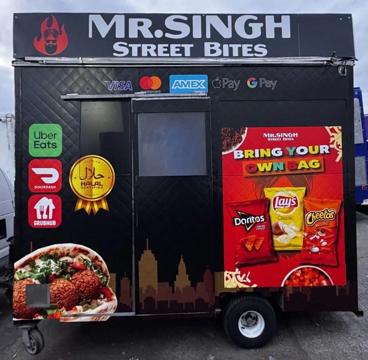 Front of the Mr. Singh Street Bites black food cart with the service window open and payment and delivery-app stickers beside it