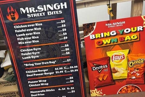 Printed Mr. Singh Street Bites menu panel in white type on black, beside a red Bring your own bag chip promotion panel