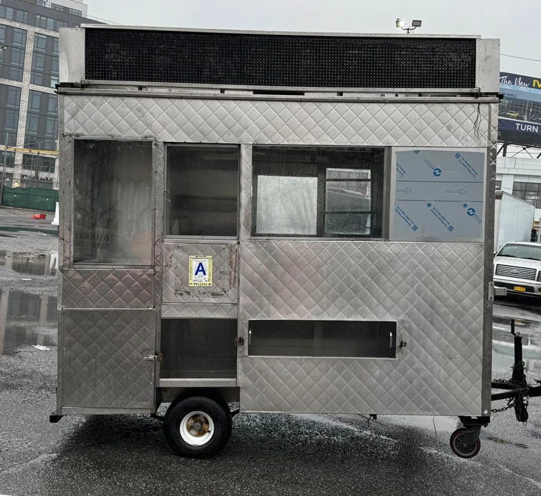 Bare stainless-steel NYC food cart before wrapping, side view
