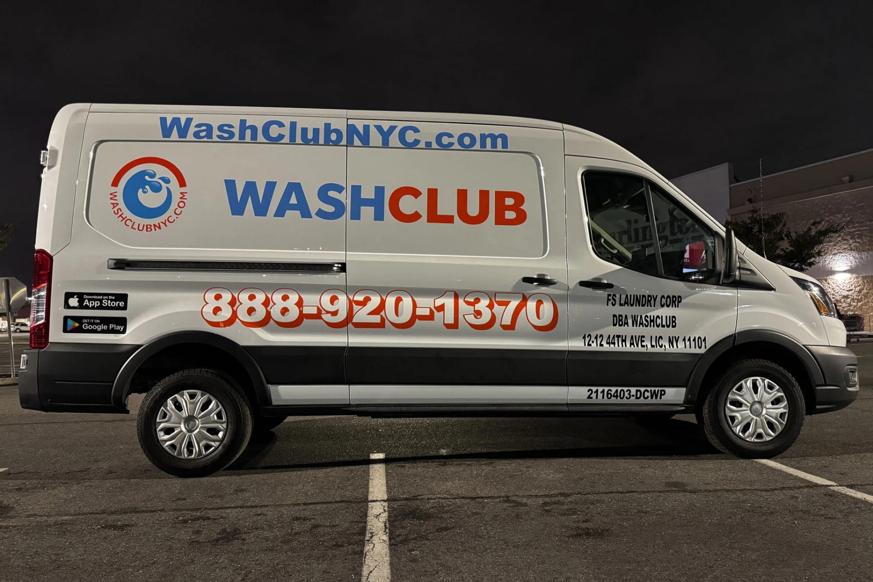 White Ford Transit for WashClub NYC with blue and orange lettering, website and phone number, side view